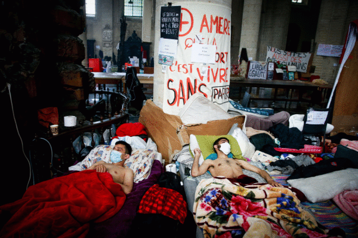 Gose greba egiten ari diren migratzaileak okupatutako San Joan Bautista elizan, Bruselan. STEPHANIE LECOCQ / EFE