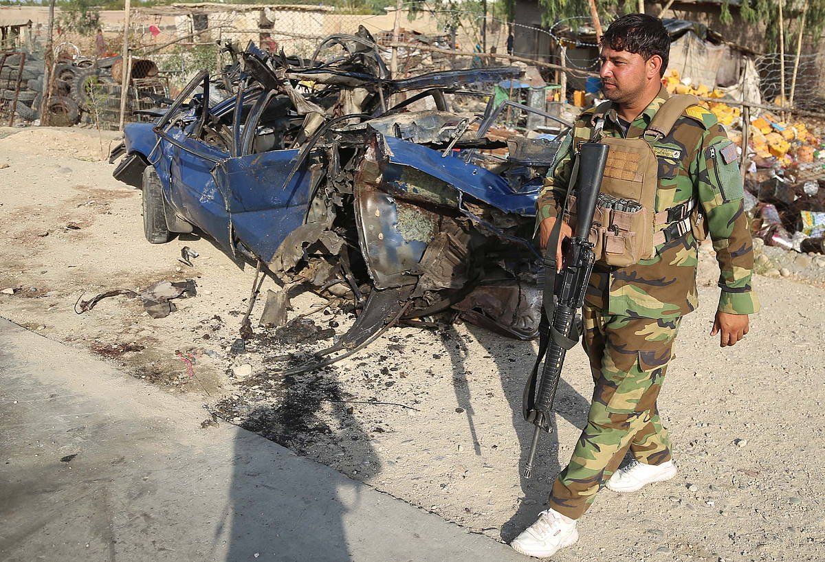Afganistango armadako soldadu bat, bonba batekin lehertarazitako auto baten alboan. GHULAMULLAH HABIBI / EFE