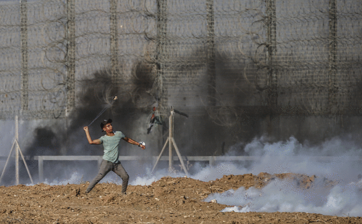 Palestinako protestari bat Israelgo indarrei harri bat botatzen, iragan larunbatean, Gazan. MOHAMMED SABER / EFE