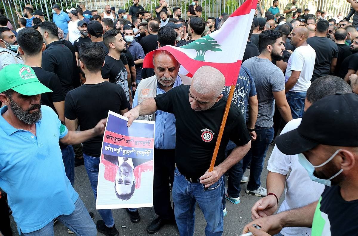 Manifestazioan parte hartu duten hainbat pertsona, Tareq Bitar epailea agertzen den kartel batekin. NABIL MOUNZER / EFE
