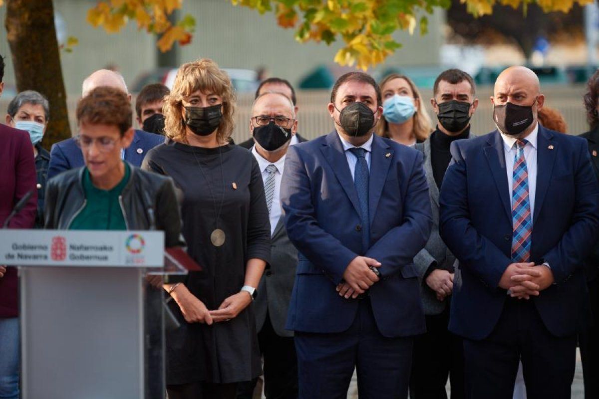 Maria Txibite adierazpena irakurtzen eta atzean gobernuko eta parlamentuko ordezkariak. NAFARROAKO PARLAMENTUA