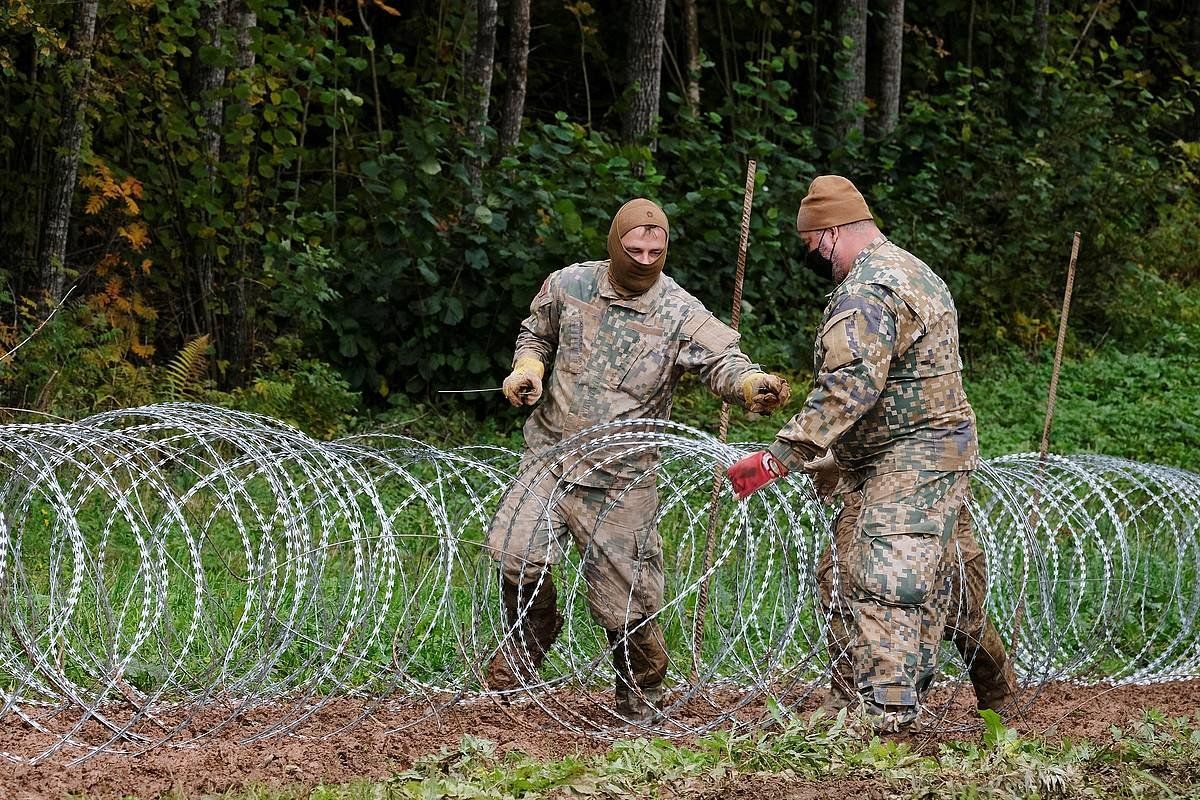 Letoniako soldaduak, Bielurrusiarekiko mugan burdin harizko labandun hesia jartzen migratzaileei bidea oztopatzeko. VALDA KALNINA, EFE