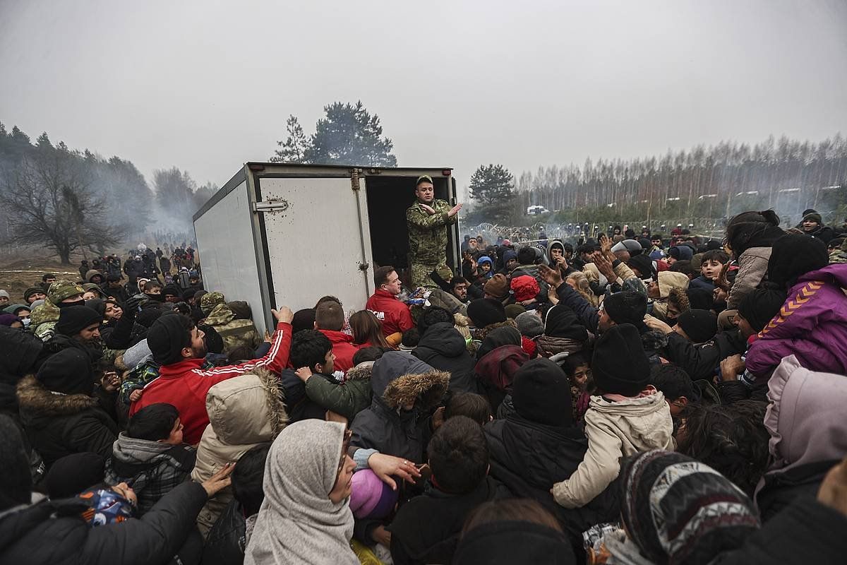 Immigranteak, atzo, Hrodnan (Bielorusia), soldaduek emandako janariaren zain. EFE