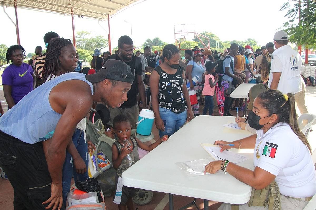 Migratzaile haitiar batzuk Mexikoko Gobernuko funtzionario batekin hizketan, atzo, Tapachulan. JUAN MANUEL BLANCO / EFE