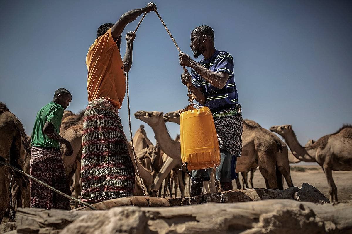 Somaliako biztanleak putzu batetik ura ateratzen, lehorteari aurre egin nahian. PABLO TOSCO/EFE