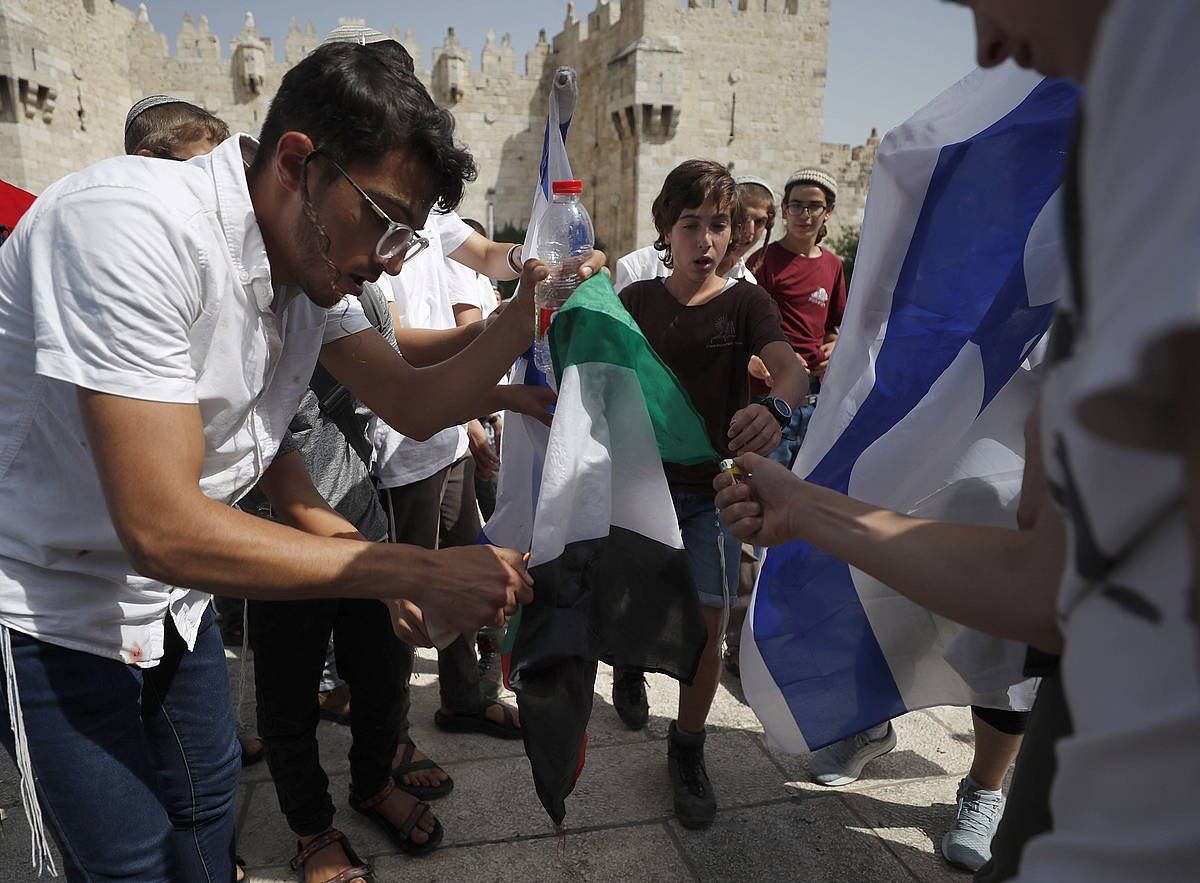 Sionista batzuk Palestinako bandera erre nahian, atzo, Jerusalemen. ATEF SAFADI / EFE
