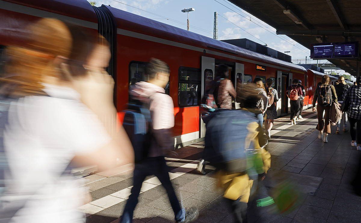 Bidaiariak, eskualdeko tren bate ondoan, Spira hiriko geltokian, bederatzi euroko txartela indarrean sartu den egunean. RONALD WITTEK / EFE / EPA