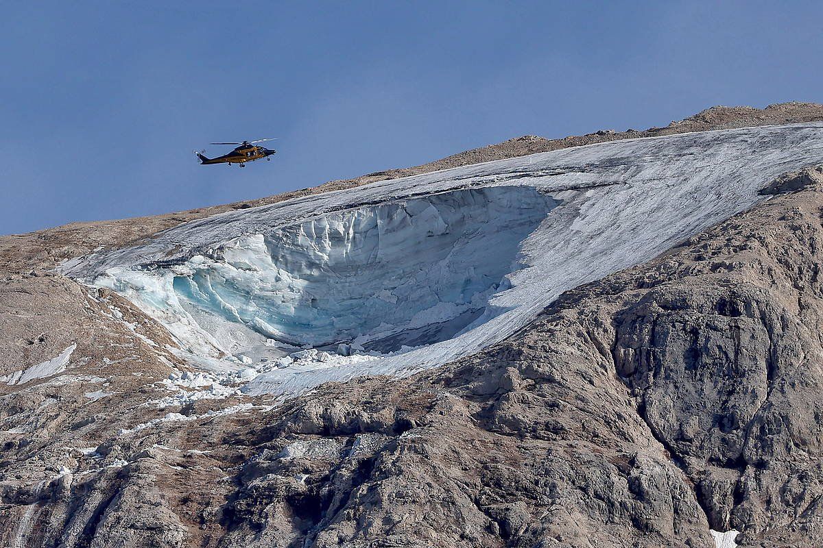 Erreskate zerbitzuen helikoptero bat Dolomitetako Marmolada glaziarraren gainean, astelehenean. ANDREA SOLERO, EFE