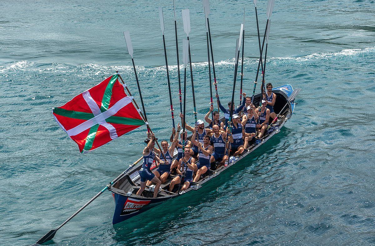 Urdaibaiko patroi Gorka Aranberri, Euskadiko Txapelketako banderarekin, arraunak goran dituztela, Leketion. ANDONI CANELLADA / FOKU