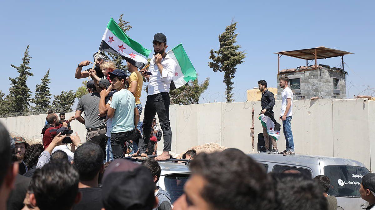 Hainbat siriar Turkiaren postu militar baten parean protestan, Idliben (Siria), aurtengo abuztuan. YAHYA NEMAH / EFE