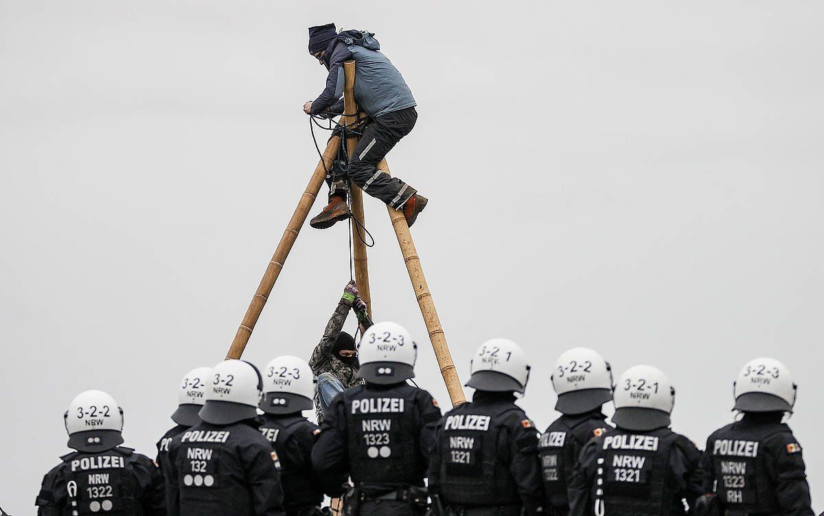 Luetzeratheko ekintzile bat, tripode batera igota eta poliziaz inguraturik, gaur. RONALD WITTEK / EFE