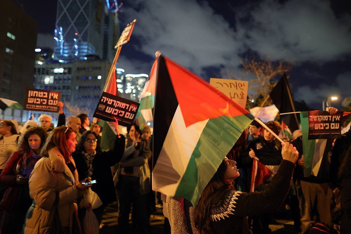 Israelgo Gobernuan aurkako manifestariak Palestinako bandera bat eskuetan dutela. ABIR SULTAN, EFE