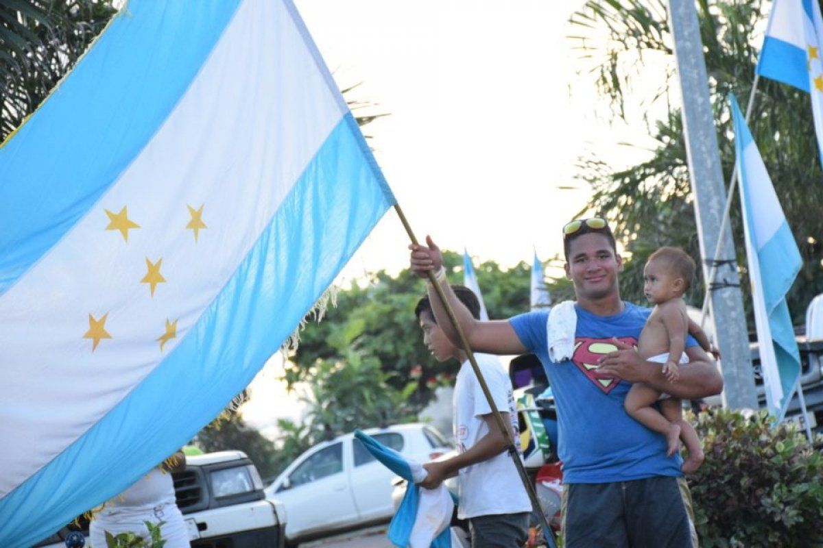 Polinesia Frantseseko herritar bat, herrialeko bandera eskutan duela. TAVINI HUIRA'ATIRA