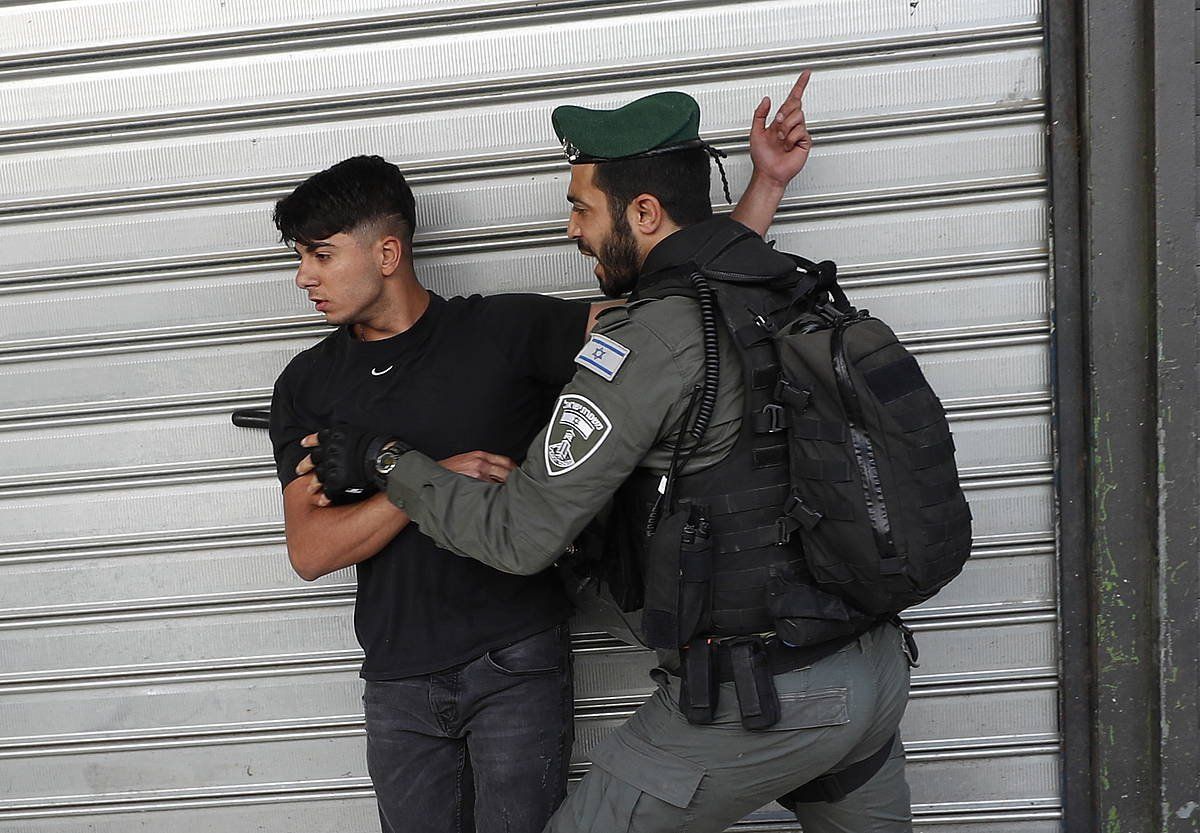 Israelgo armadako kide bat palestinar bat atxikita duela, maiatzaren 18an, Banderen Martxaren egunean, Jerusalemgo hiri zaharrean. ATEF SAFADI / EFE