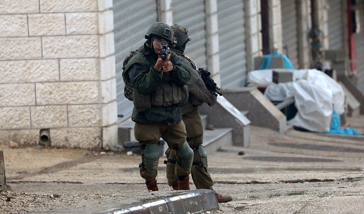 Israelgo armadako bi soldadu, Hawaran (Zisjordania), palestinar bat atxilotzeko operazio batean, martxoan. ALAA BADARNEH / EFE