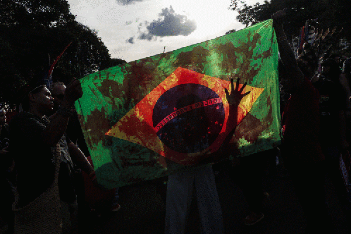 Zenbait manifestari Brasilgo bandera eusten, odolez zikinduta, lege proiektuaren aurkako manifestazioan, Sao Paulon. ANDRE COELHO / EFE
