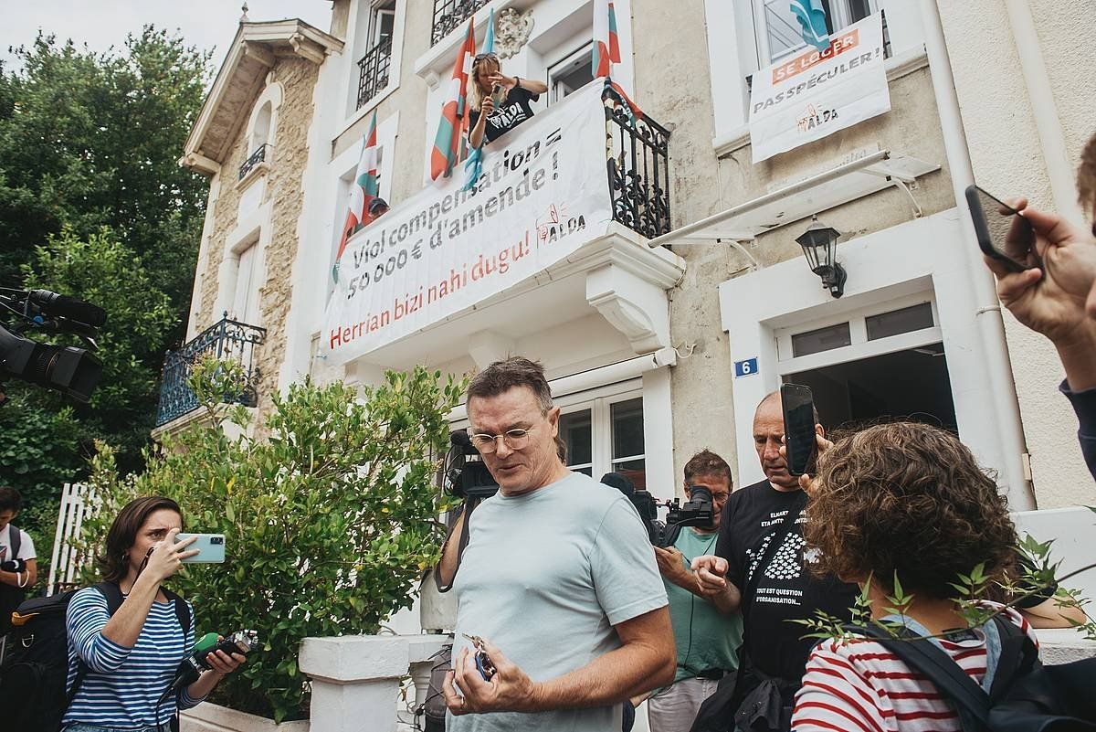 Etxebizitzako jabea, kazetariez eta Aldako kideez inguratua, etxebizitzatik alde egin duenean. GUILLAUME FAUVEAU