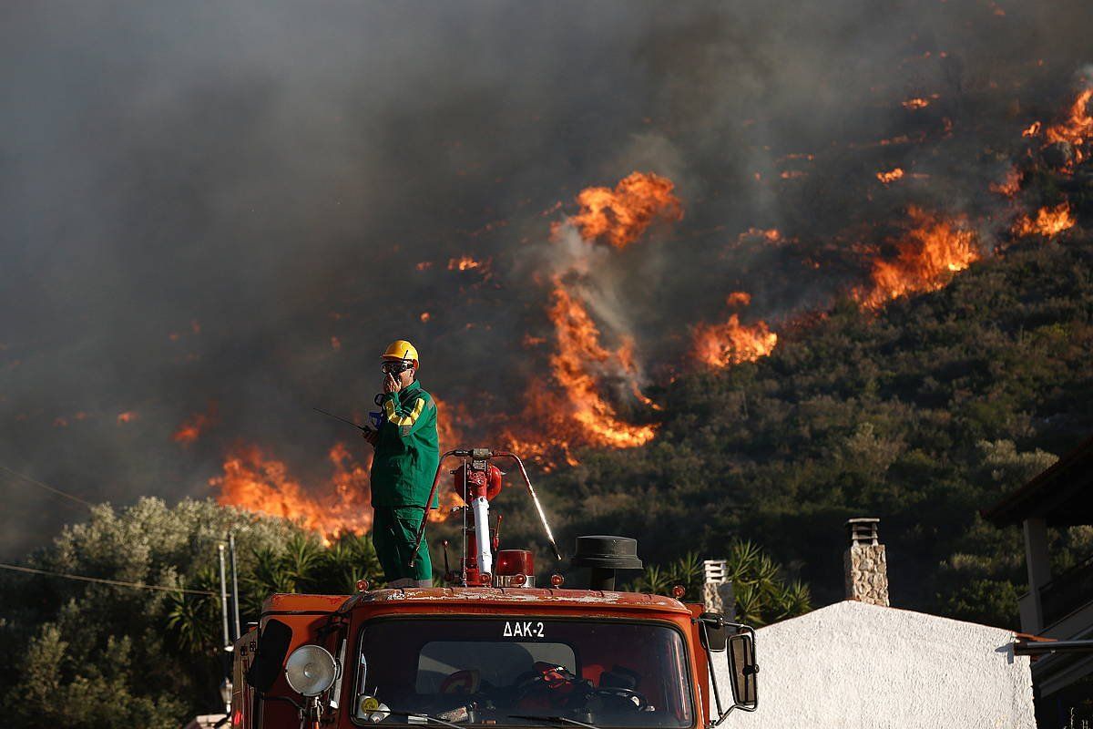 Suhiltzaile bat, lanean, suteek kiskalitako eremutik gertu, atzo, Attican (Grezia). YANNIS KOLESIDIS / EFE