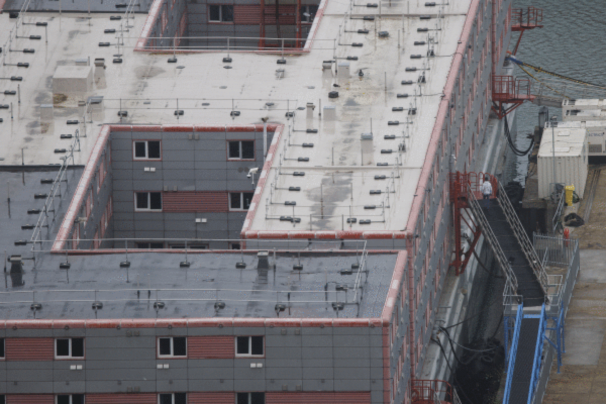 Asilo eskatzaile bat Portlandeko Bibby Stockholm errefuxiatuentzako itsasontzira sartzen, abuztu hasieran. TOLGA AKMEN / EFE