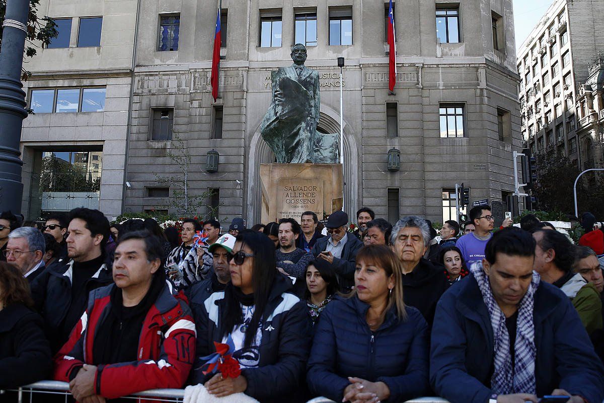 Hainbat herritar Santiagon, Allenderen estatuaren aurrean, Moneda jauregiaren atzealdean. ELVIS GONZALEZ, EFE