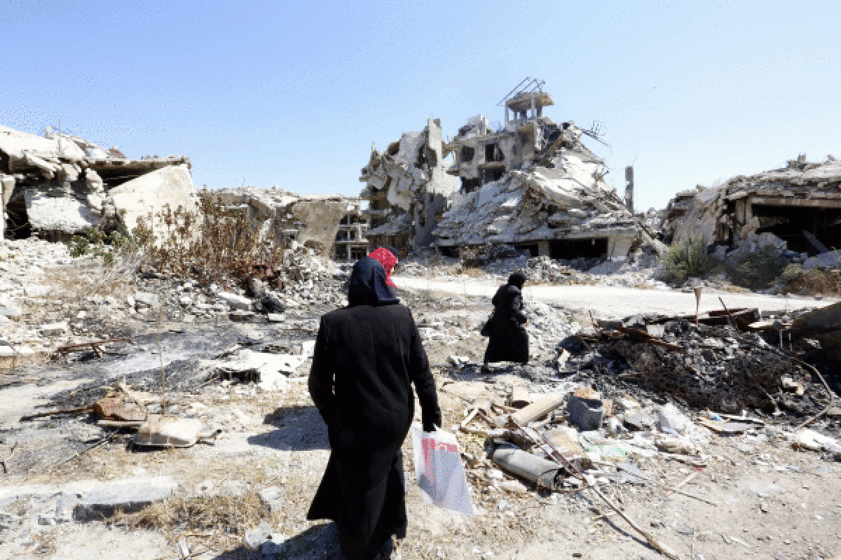 Bi emakume bonbek utzitako arrastoen artean oinez, Homs hirian, Sirian, 2016an. YOUSSEF BADAWI / EFE