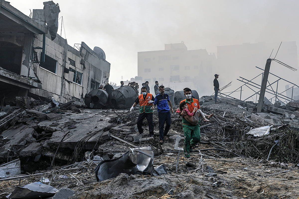 Palestinar batzuk Gaza Hirian hondakinen artetik neska bat ateratzen. MOHAMMED SABER, EFE