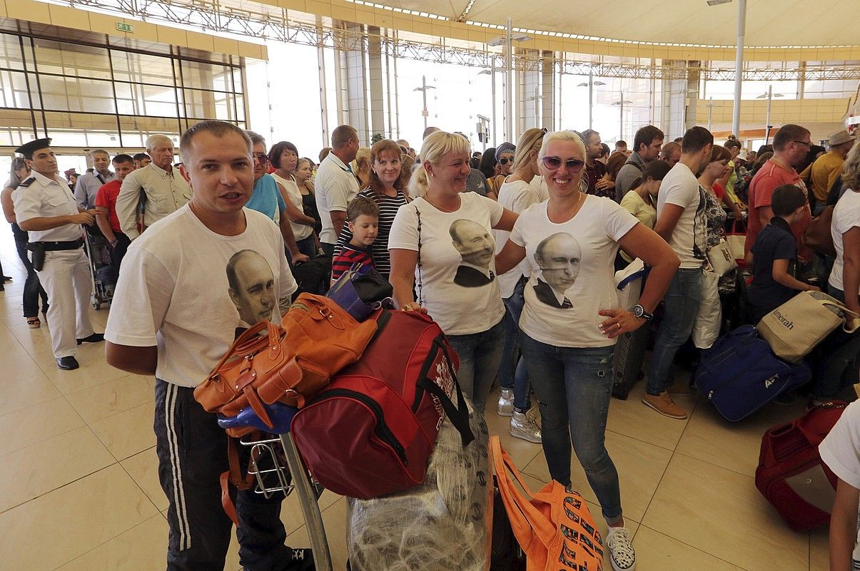 Turista errusiarrak Xarm el-Xeikheko aireportuan, atzo, Vladimir Putinen irudia daukaten elastikoak jantzita. KHALED ELFIQI / EFE. Turista errusiarrak Xarm el-Xeikheko aireportuan, atzo, Vladimir Putinen irudia daukaten elastikoak jantzita. KHALED ELFIQI / EFE.