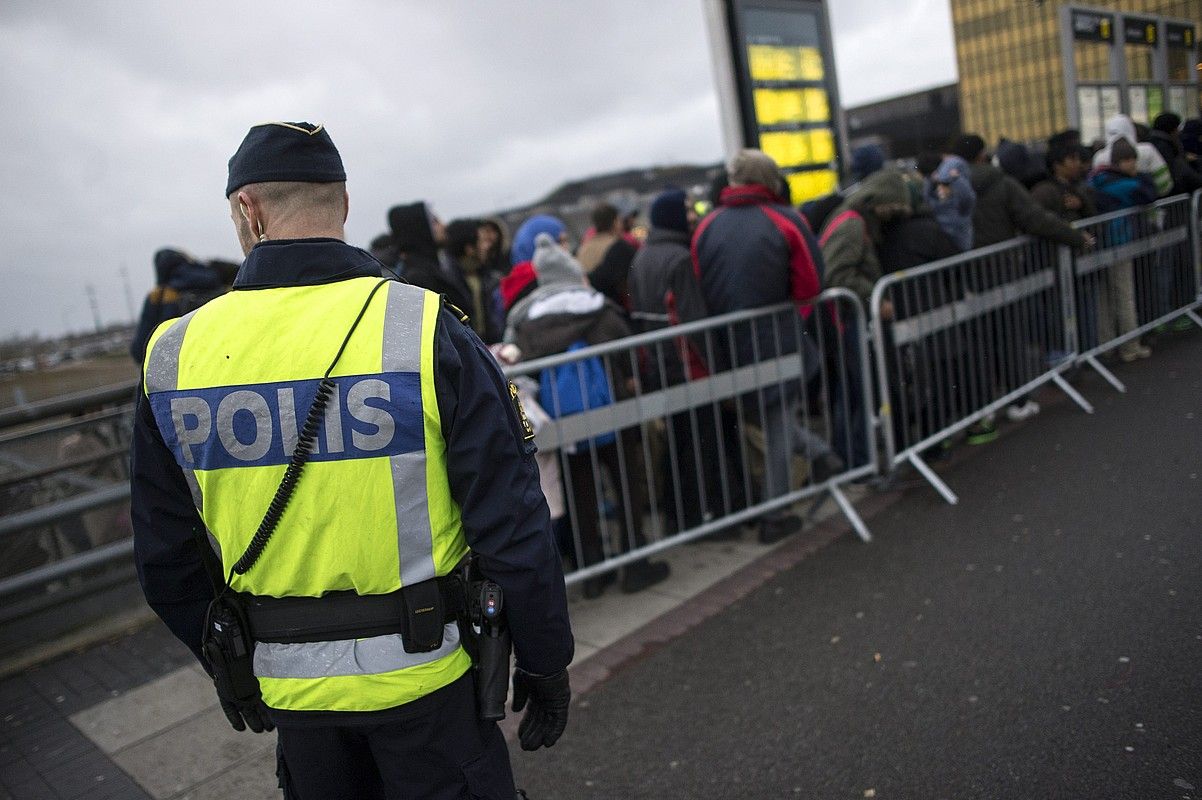 Suediako polizia bat, iheslari talde bat zaintzen, iragan azaroan, Malmoko tren geltokian. JOHAN NILSSON / EFE. Suediako polizia bat, iheslari talde bat zaintzen, iragan azaroan, Malmoko tren geltokian. JOHAN NILSSON / EFE.
