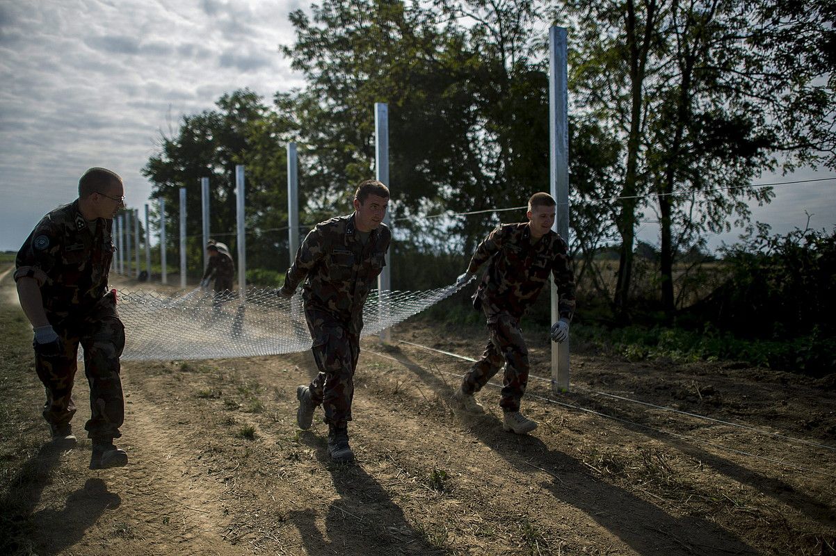 Hungariako soldaduak, duela astebete, hesia eraikitzen Kroaziako mugaldean. TAMAS SOKI / EFE. Hungariako soldaduak, duela astebete, hesia eraikitzen Kroaziako mugaldean. TAMAS SOKI / EFE.