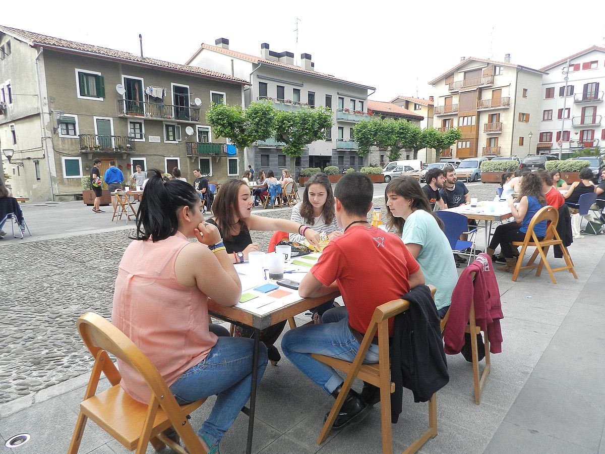 Hainbat gazte, talde txikitan, Bizentaren Lumak karta jolasean, Astigarragan egindako saioan. ELHUYAR AHOLKULARITZA.