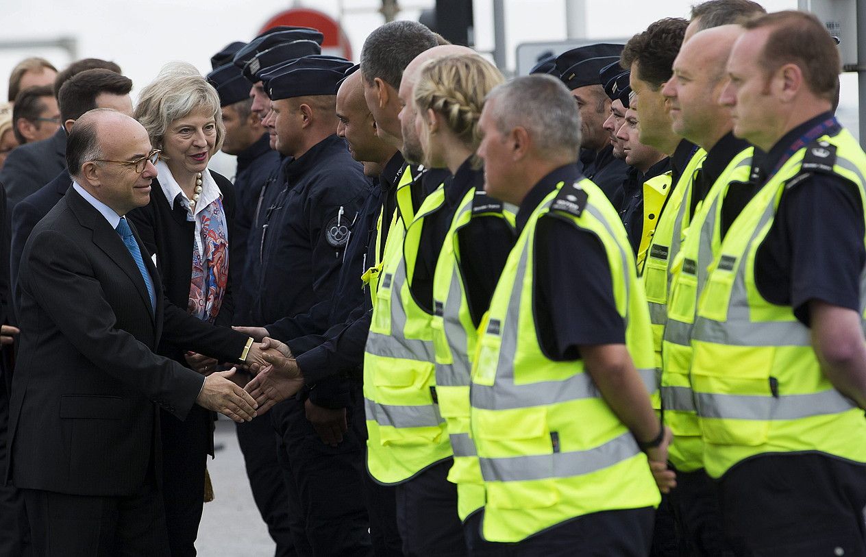 Bernad Cazeneuve eta Theresa May, polizia frantses eta ingelesak agurtzen, Calaisen. IAN LANGSDON / EFE.