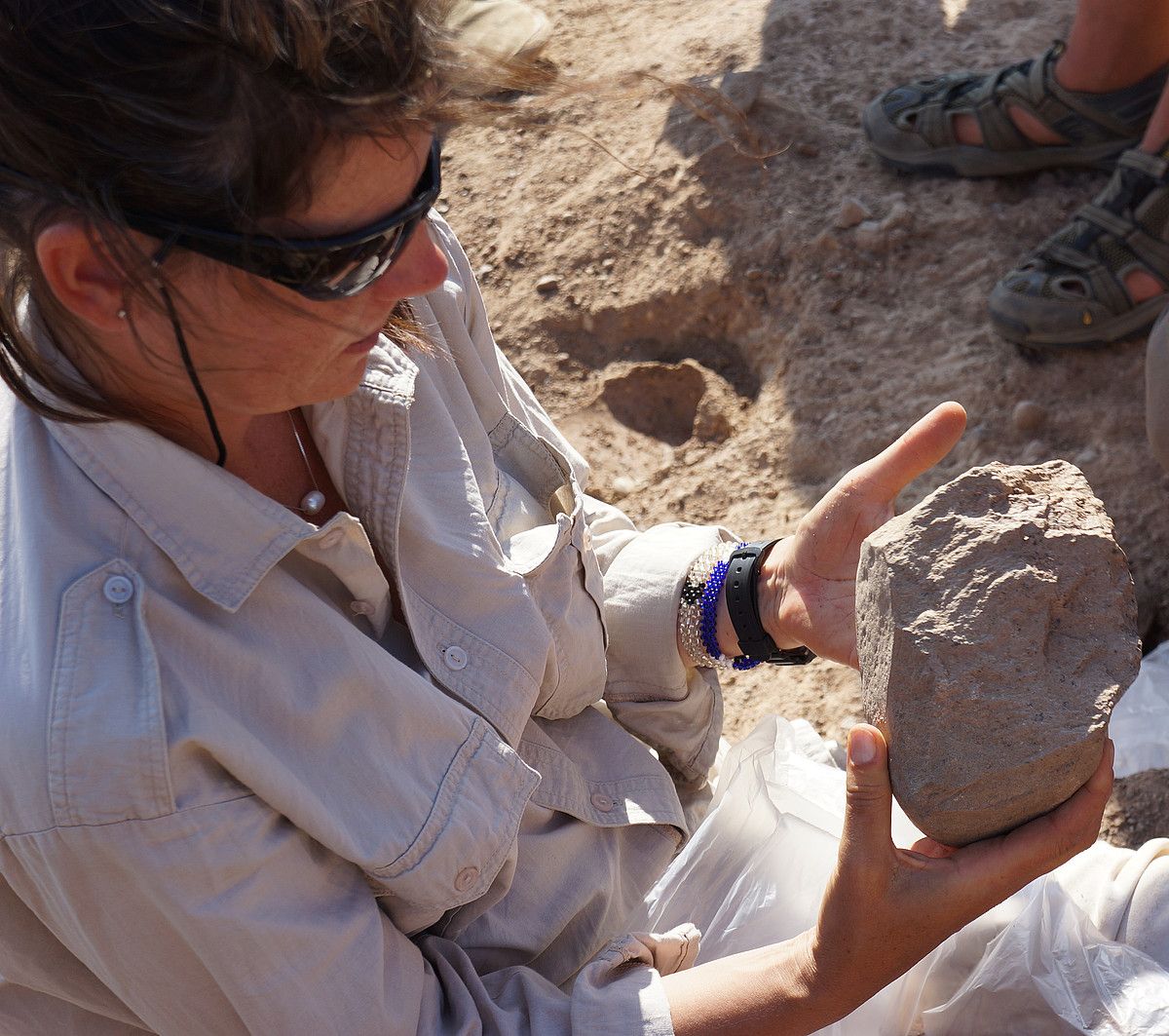 Sonia Harmand arkeologoa, Kenyan topatutako harrizko tresna bat aztertzen. NATURE.