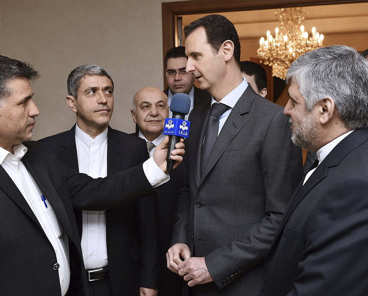 Baxar al-Assad Siriako presidentea, kazetari bati erantzuten, Irango Ekonomia ministroarekin (ezkerretik bigarrena) elkartu ondoren, atzo, Damaskon. SANA / EFE. Baxar al-Assad Siriako presidentea, kazetari bati erantzuten, Irango Ekonomia ministroarekin (ezkerretik bigarrena) elkartu ondoren, atzo, Damaskon. SANA / EFE.