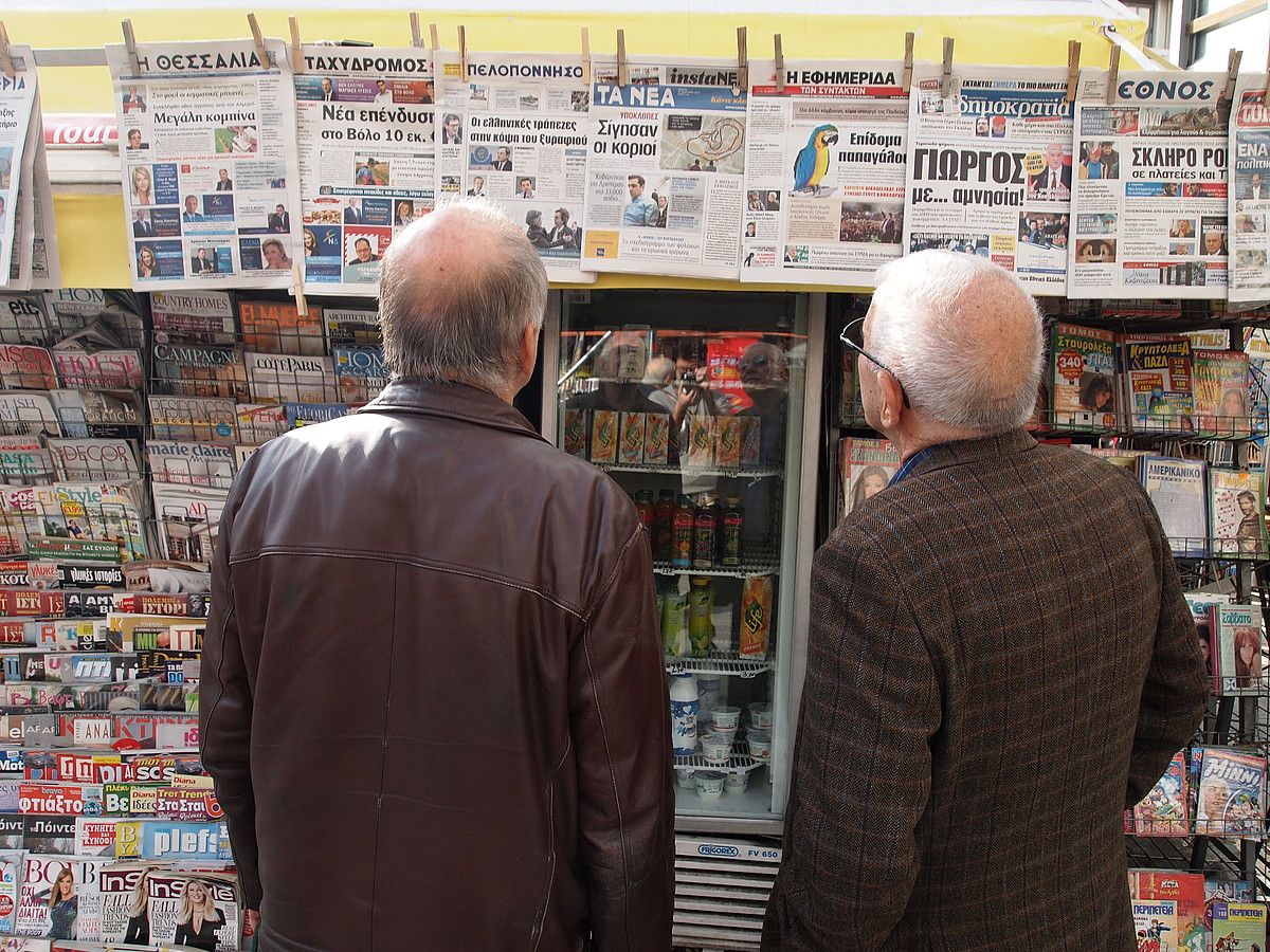 Herritarrak egunkariak irakurtzen Atenasko kiosko batean, atzo. JON FERNANDEZ.