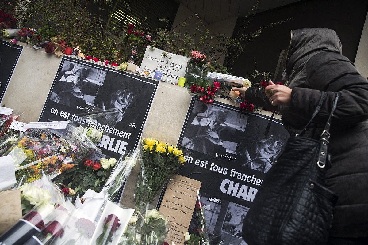 Emakume bat loreak uzten Charlie Hebdo astekariaren egoitzan, atzo, Parisen. ETIENNE LAURENT / EFE.