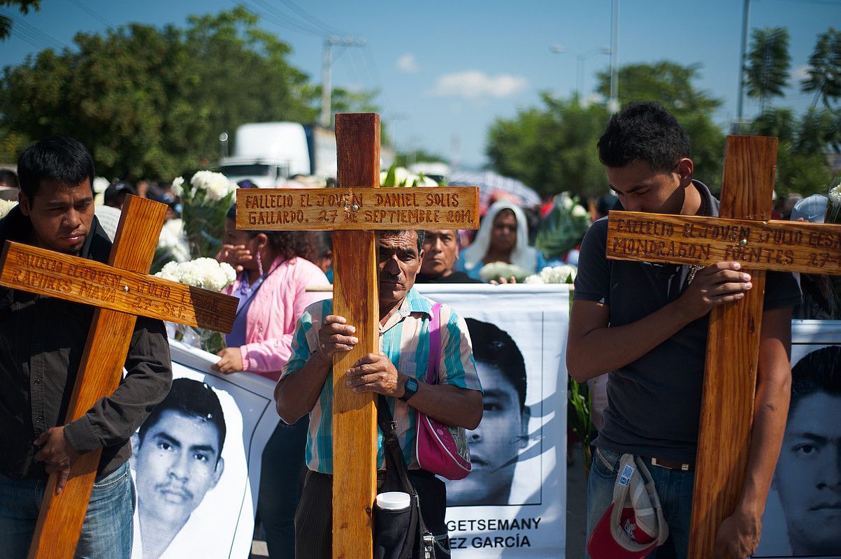 Goian, Enrique Peña Nieto Time aldizkariaren azalean, Mexiko salbatzen tituluarekin. Ondoan, Ayotzinapako ikasleak eta gurasoak, urriaren 27an, hildakoen eta desagerrarazien alde. PEP COMPANYS.