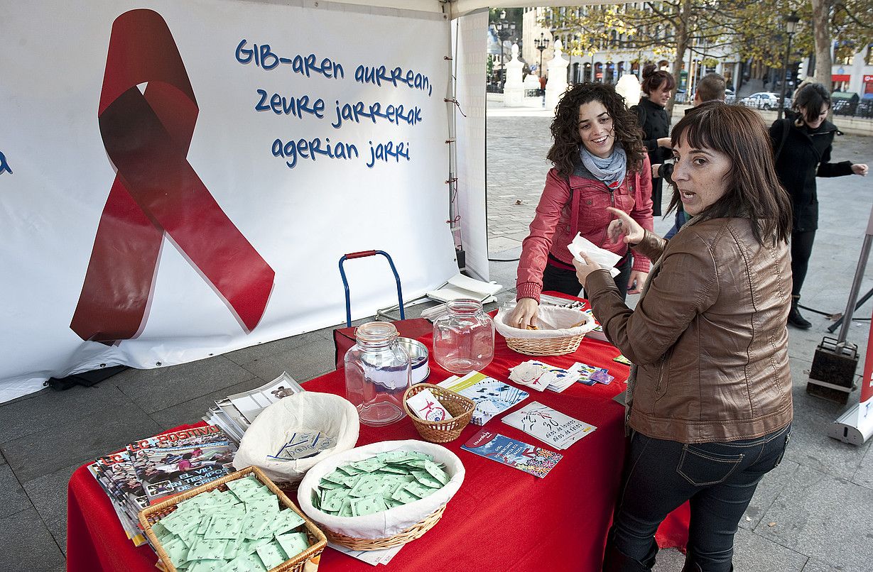 Hainbat pertsona, hiesari buruzko informazioa zabaltzeko mahai batean, Bilbon egindako ekitaldi batean. JON HERNAEZ / ARGAZKI PRESS. Hainbat pertsona, hiesari buruzko informazioa zabaltzeko mahai batean, Bilbon egindako ekitaldi batean. JON HERNAEZ / ARGAZKI PRESS.