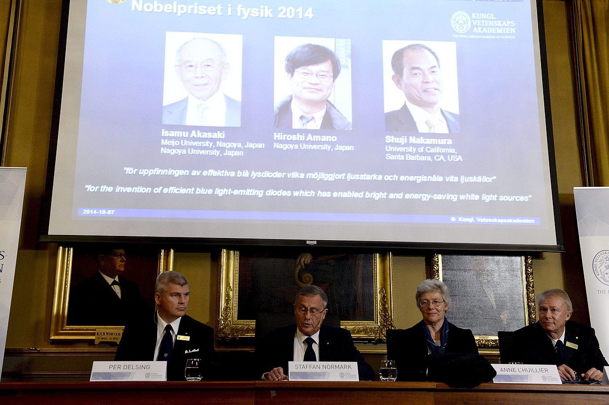 Isamu Akasaki, Hiroshi Amano eta Shuji Nakamuraren argazkiak —goian—, saria iragartzeko ekitaldian. BERTIL ERICSON / EFE. Isamu Akasaki, Hiroshi Amano eta Shuji Nakamuraren argazkiak —goian—, saria iragartzeko ekitaldian. BERTIL ERICSON / EFE.