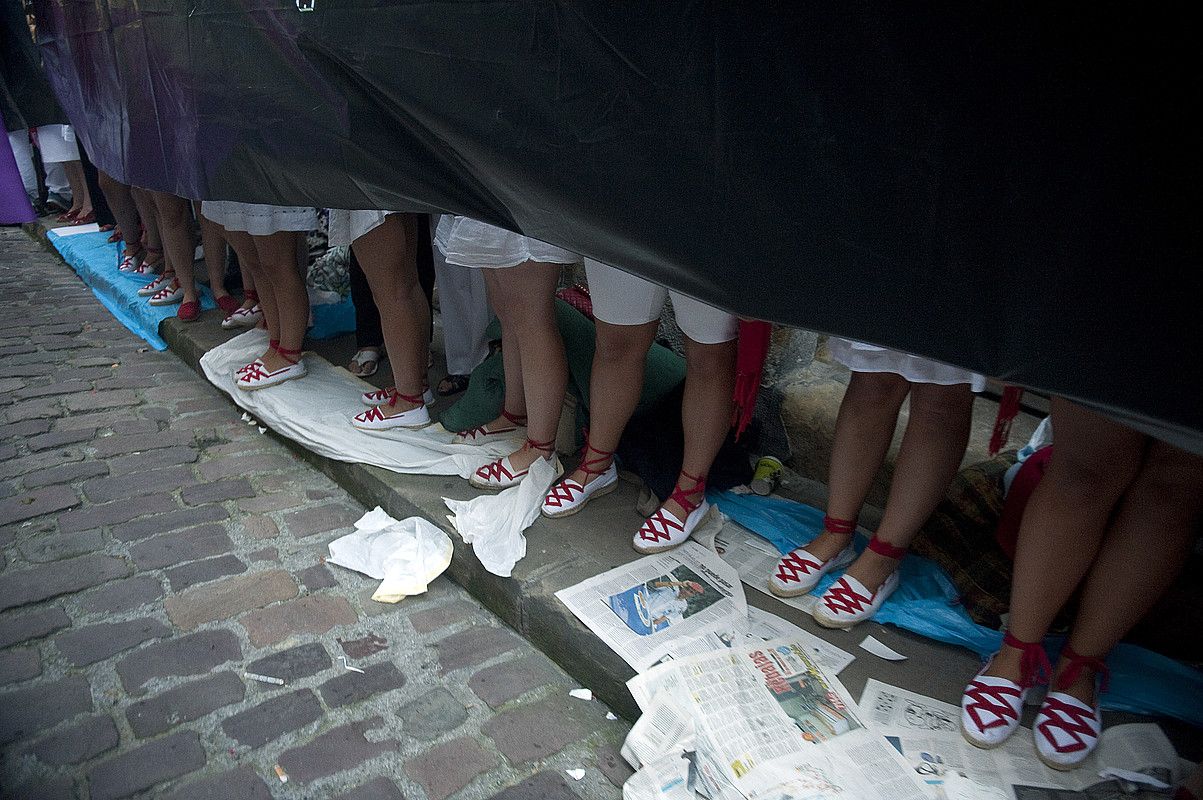 Plastiko beltza kalean alderik alde jarrita, ezinikusia agertzen diote Jaizkibel konpainia parekideari. Neska gazteak izan ohi dira maiz plastiko horien eusle. JUAN CARLOS RUIZ / ARGAZKI PRESS.