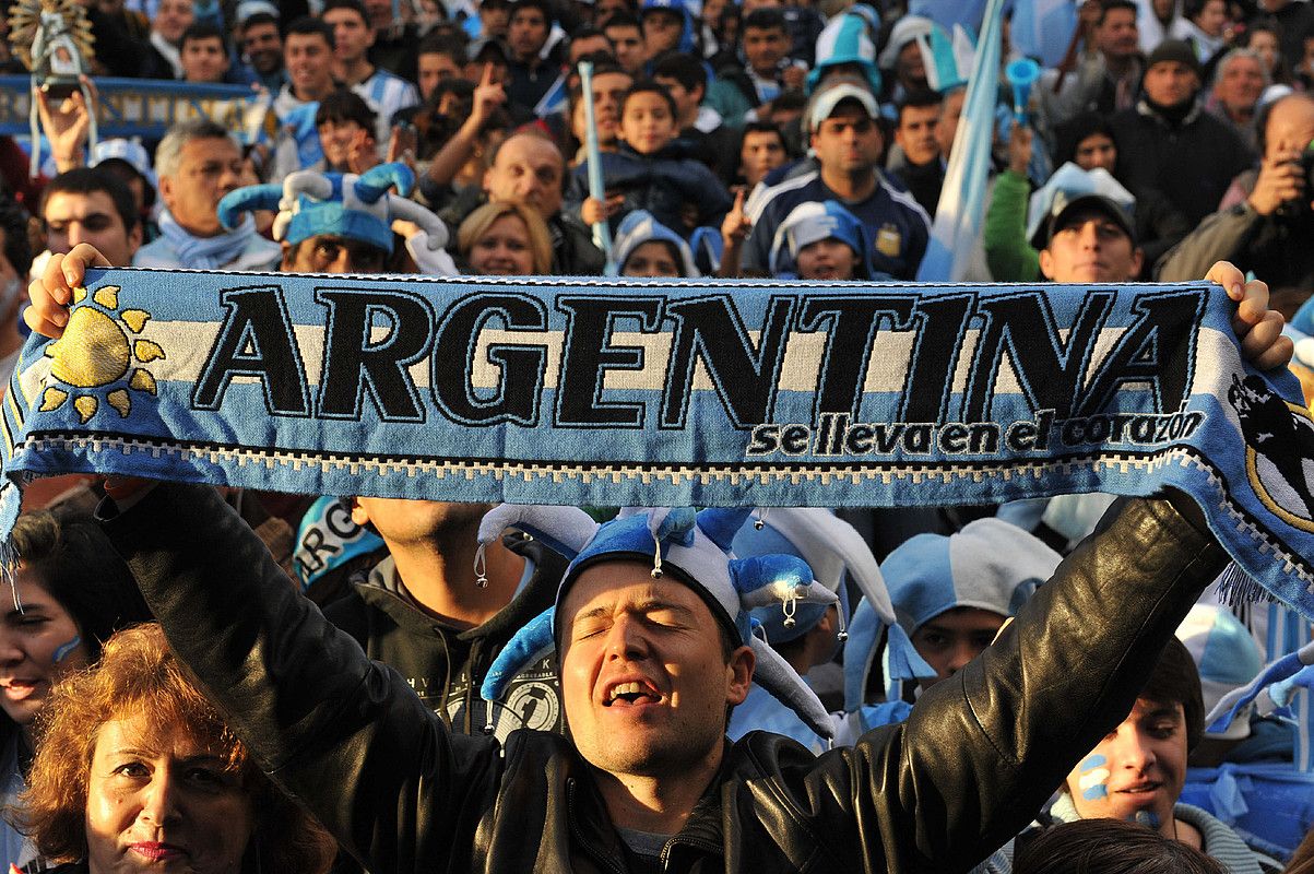 Zale bat, Argentina bihotzean eramaten da leloa duen bufanda erakusten, Buenos Airesko ospakizunetan. E. G. M. / EFE. Zale bat, Argentina bihotzean eramaten da leloa duen bufanda erakusten, Buenos Airesko ospakizunetan. E. G. M. / EFE.