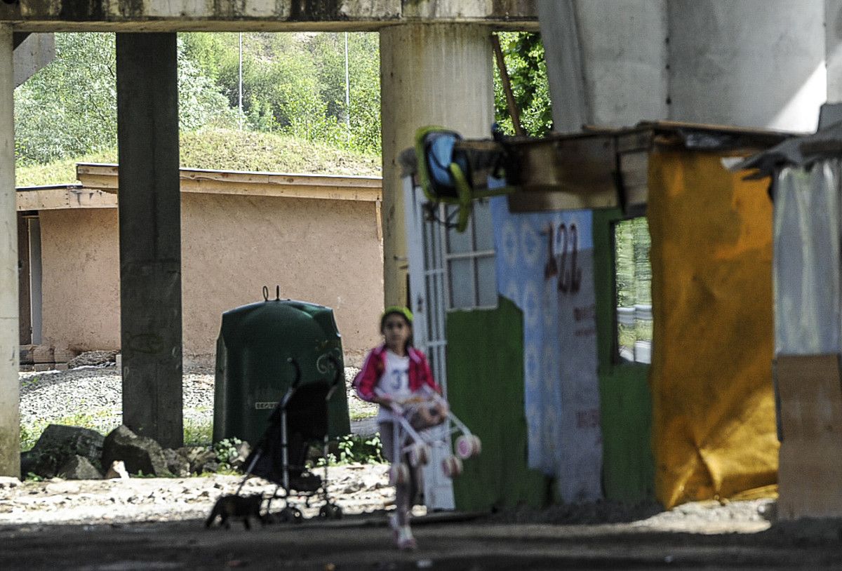 Neskato bat, atzo, Urumea ibaiaren ertzean Errumaniatik etorritako etorkinek duten kanpalekuan; zubipean bizi dira, baina plan bat martxan da gizarteratzen laguntzeko. JAGOBA MANTEROLA / ARGAZKI PRESS.