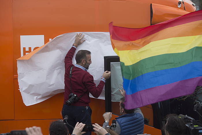 Gizon bat Hazte Oirren autobuseko mezuak estaltzen, protesta artean. IñIGO URIZ, ARGAZKI PRESS