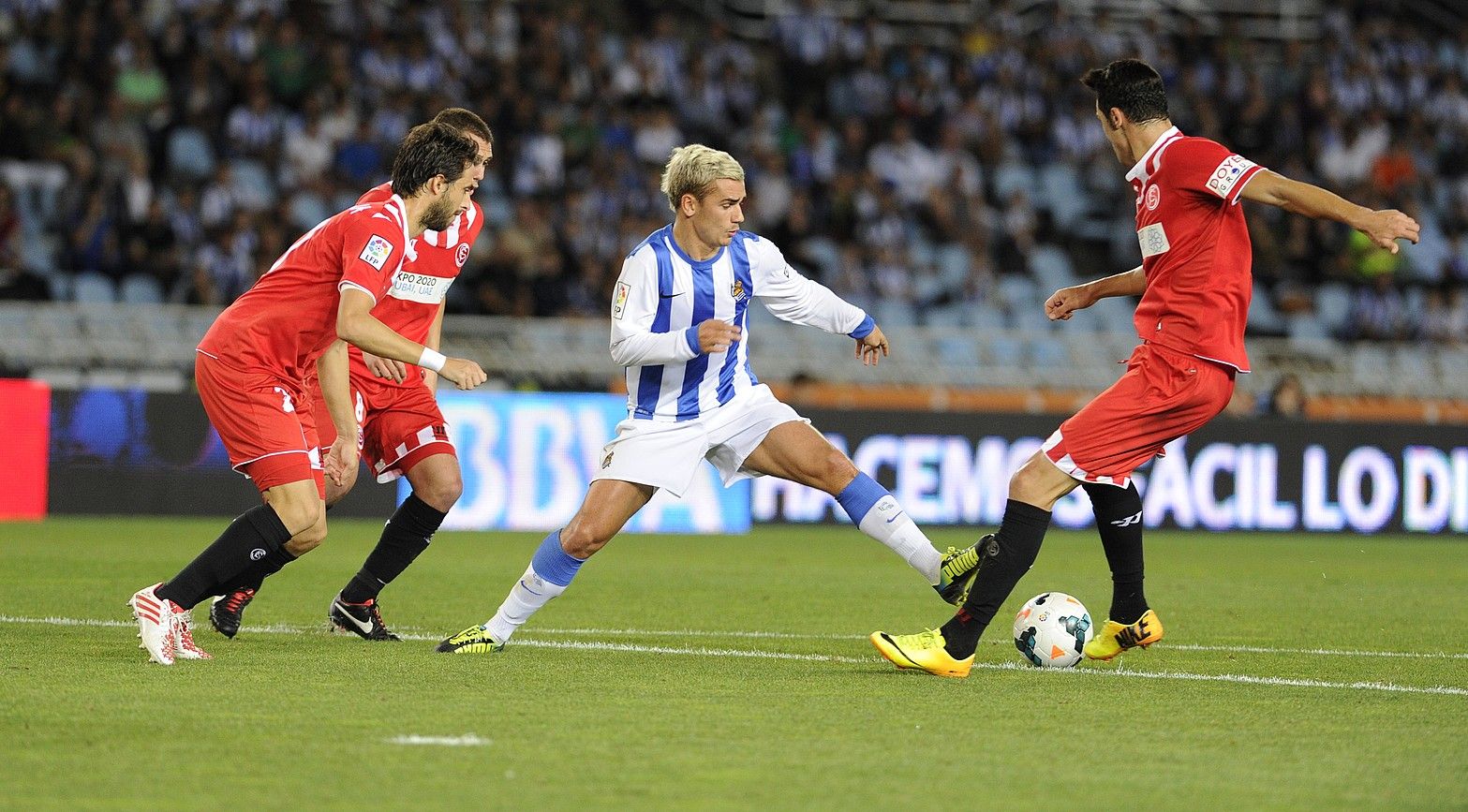 Antoine Griezmann Realeko aurrelaria baloia kontrolatzen saiatzen, Sevillako hiru atzelariren artean, atzoko partidako jokaldi batean. JON URBE / ARP. Antoine Griezmann Realeko aurrelaria baloia kontrolatzen saiatzen, Sevillako hiru atzelariren artean, atzoko partidako jokaldi batean. JON URBE / ARP.