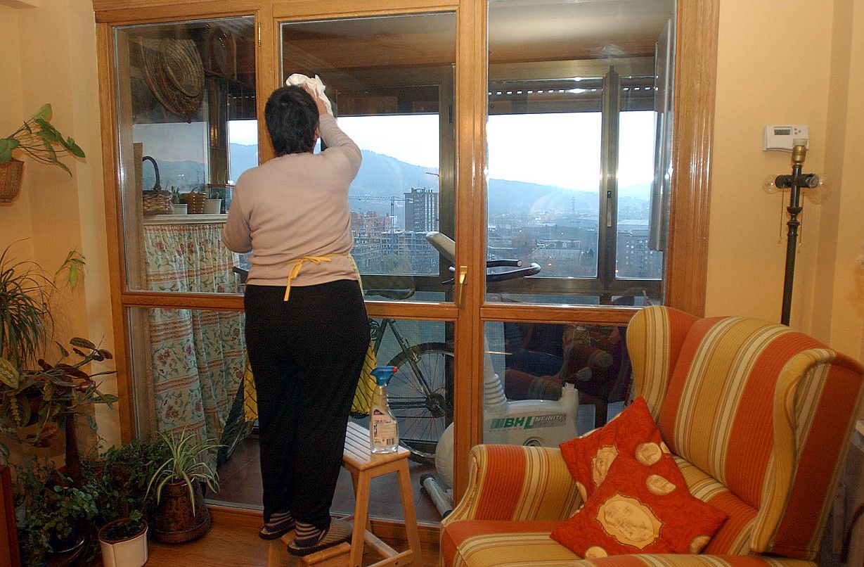 Emakume bat etxeko leihoak garbitzen. MONIKA DEL VALLE / FOKU