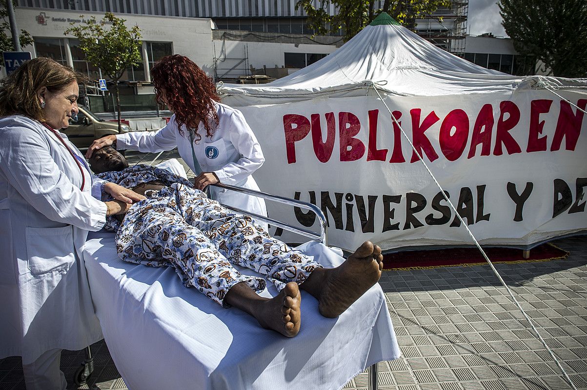 Osasun Publikoaren Aldeko Plataformak antolatuta, etorkinak artatzen ari diren itxura eginez egin zuten protesta abuztuan Iruñean. LANDER F. ARROIABE / ARP.