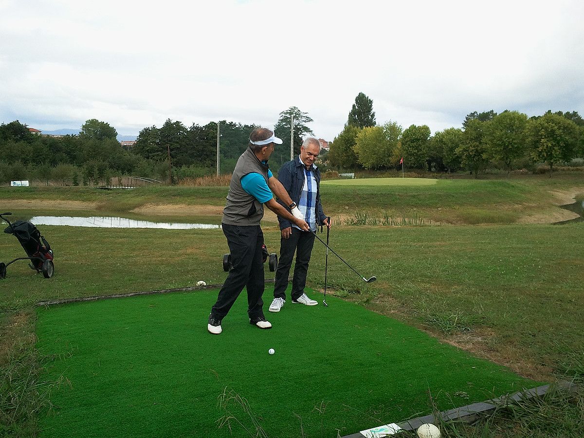 Jose Luis Korta, Kaikuko entrenatzailea, Xabier Euzkitze aurkezlearekin golfean, Bisitaria saioko lehen atalean. ETB. Jose Luis Korta, Kaikuko entrenatzailea, Xabier Euzkitze aurkezlearekin golfean, Bisitaria saioko lehen atalean. ETB.