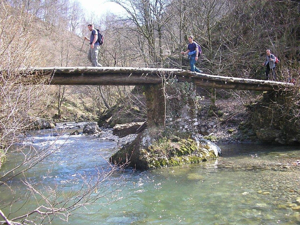 Nafarroa, Lapurdi eta Gipuzkoatik pasatzen da bidea. Irudian, mendizale batzuk, mendi ibilbidea egiten, zubi baten gainetik pasatzen. BERRIA.