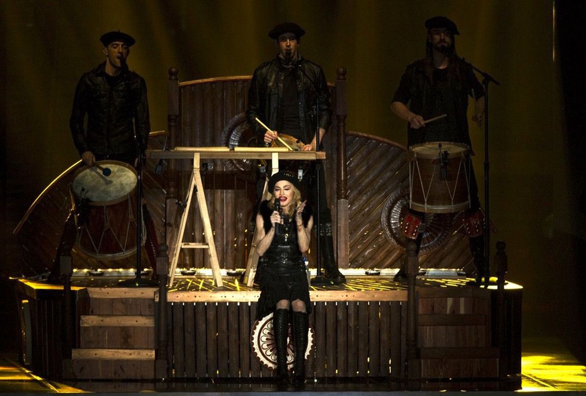 Kalakan taldeko hiru kideak, Madonnaren atzealdean, birako emanaldi batean. MADONNARAMA.