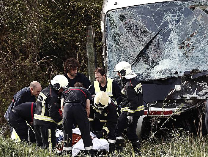 Larrialdi zerbitzuak Lantzen, istripua gertau den tokian lanean, ezbeharra izan duen autobusa atzean dutela. JDIGES, EFE