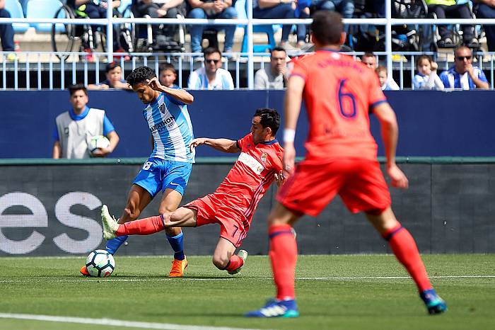 Juanmi Realeko aurrelaria, Rosales Malagako atzelariari baloia lapurtu nahian. CARLOS DIAZ, EFE
